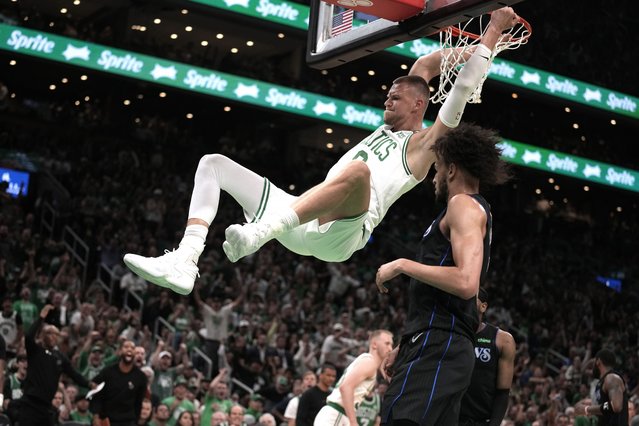 Boston Celtics center Kristaps Porzingis dunks next to Dallas Mavericks center Dereck Lively II, foreground, during the first half of Game 1 of basketball's NBA Finals on Thursday, June 6, 2024, in Boston. (Photo by Charles Krupa/AP Photo)