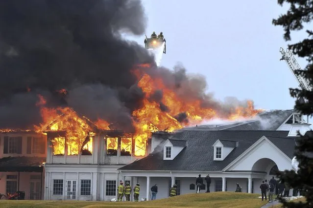 A fire burns at the main building at Oakland Hills Country Club in Bloomfield Township, Mich., on Thursday, February 17, 2022. Firefighters battled a blaze at a more than century-old country club Thursday in suburban Detroit that's hosted several major golf tournaments and is one of Michigan‚Äôs most exclusive golf clubs.(Photo by Daniel Mears/Detroit News via AP Photo)