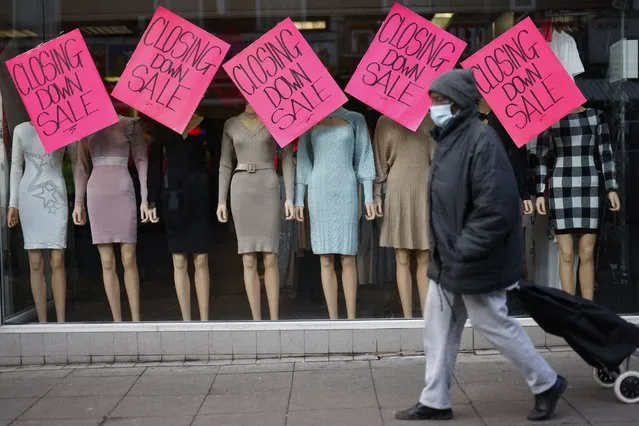 A pedestrian walks past “Closing Down Sale” signs in the window of a clothes shop in Walthamstow, east London on February 4, 2022. The UK government on Thursday stepped in to help the hardest-hit households struggling with the rising cost of living, announcing a £9 billion package to offset soaring energy bills. (Photo by Tolga Akmen/AFP Photo)