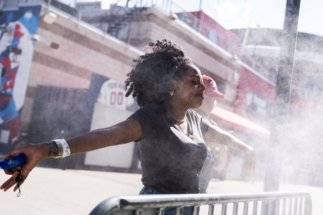 A fan cools off in mist before the Congressional Baseball Game at Nationals Park on Wednesday, June 12, 2024.(Tom Williams/CQ-Roll Call, Inc via Getty Images)