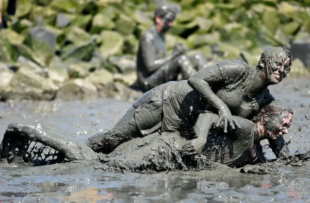 Participants fight for the ball during a handball match at the so called “Wattoluempiade” (Mud Olympics) in Brunsbuettel at the North Sea, July 11, 2015. (Photo by Fabian Bimmer/Reuters)