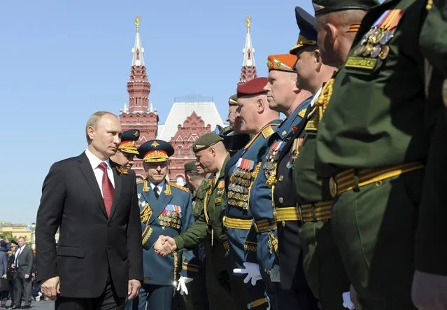 Russian President Vladimir Putin (L) meets servicemen during celebrations to mark Victory Day in Moscow's Red Square May 9, 2014. Putin praised the Soviet role in defeating fascism on Friday, the anniversary of the World War Two victory over Nazi Germany, and said those who defeated fascism must never be betrayed. (Photo by Mikhail Klimentyev/Reuters)