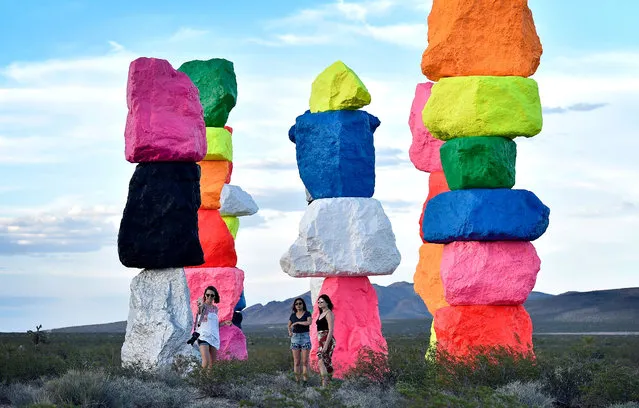 People take a selfie as they visit the large-scale public art installation titled Seven Magic Mountains by Swiss artist Ugo Rondinone on May 14, 2016 near Jean, Nevada. The artwork, comprised of seven towers of colorful, stacked boulders standing more than thirty feet high, was recently completed in the desert south of Las Vegas. (Photo by David Becker/AFP Photo)