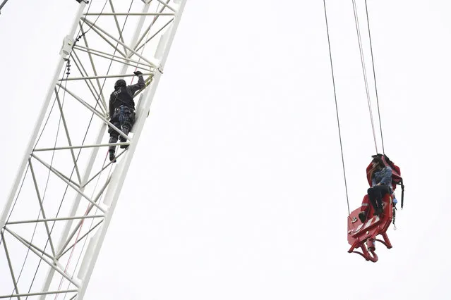 A woman is rescued from a downtown Toronto crane early Wednesday, April 26, 2017. Some streets in the downtown core were closed as dozens of construction workers and commuters gazed skyward to watch police and firefighters try to rescue the woman who got stuck atop the tall construction crane. (Photo by Frank Gunn/The Canadian Press via AP Photo)