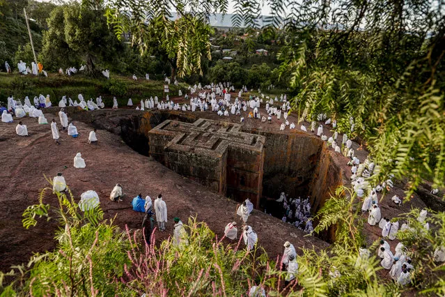 Ethiopian pilgrims gather at the Saint George (or Bet Giyorgis) Church during Saint George's festival in Lalibela, Ethiopia, 04 October 2019. The church of Saint George is one of eleven churches in Lalibela. The religious buildings were built at the height of medieval Ethiopian civilization from the ninth to the 12th century AD. The site of Lalibela is registered by UNESCO with the cultural inheritance of humanity since 1978. In order to protect the churches, roofs were installed above each of them except for the Church Saint Georges, which allows construction evacuation of water during heavy rains to minimize erosion. (Photo by Stéphanie Lecocq/EPA/EFE)