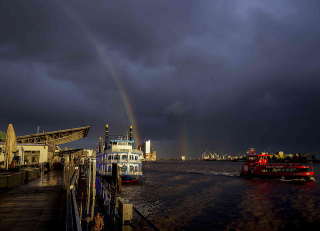 A rainbow appears over the harbor of Hamburg, Germany, after a storm Thursday, October 21, 2021. (Photo by Michael Probst/AP Photo)