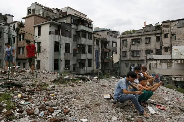 Residents rest on wreckage of houses in Xian village, a slum area in downtown Guangzhou, China July 24, 2015. (Photo by Tyrone Siu/Reuters)