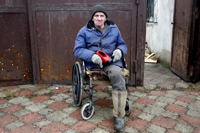 Resident Viktor Gudelya, who lost a leg during a 2014 shelling, watches firemen extinguishing a fire in his house in Avdiivka, destroyed as a result of heavy shelling by pro-Russian rebels on February 25, 2017. (Photo by Anatolii Stepanov/AFP Photo)