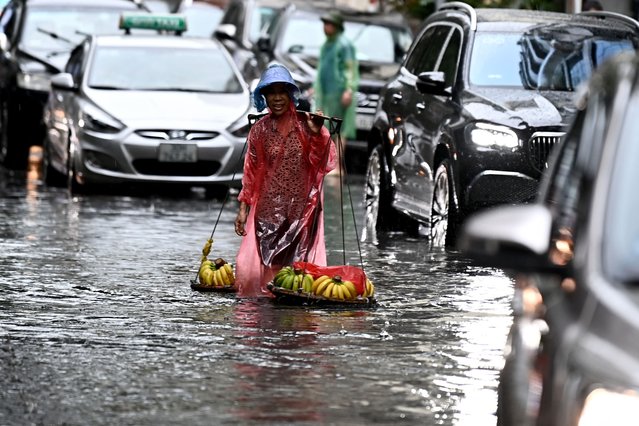 A banana vendor wades in a flooded street in Hanoi on June 5, 2024. (Photo by Nhac Nguyen/AFP Photo)