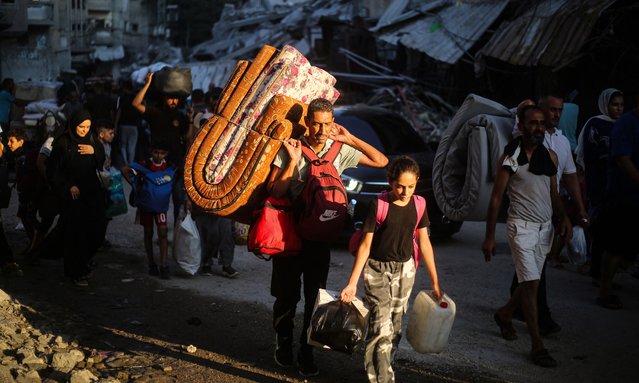 Palestinians carrrying their personal belongings flee the al-Bureij refugee camp in the central Gaza Strip on July 28, 2024, amid the ongoing conflict between Israel and the militant group Hamas. (Photo by Eyad Baba/AFP Photo)