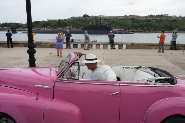 A driver parks a vintage car as Russian nuclear-powered cruise missile submarine Kazan enters Havana’s bay, Cuba, on June 12, 2024. (Photo by Alexandre Meneghini/Reuters)