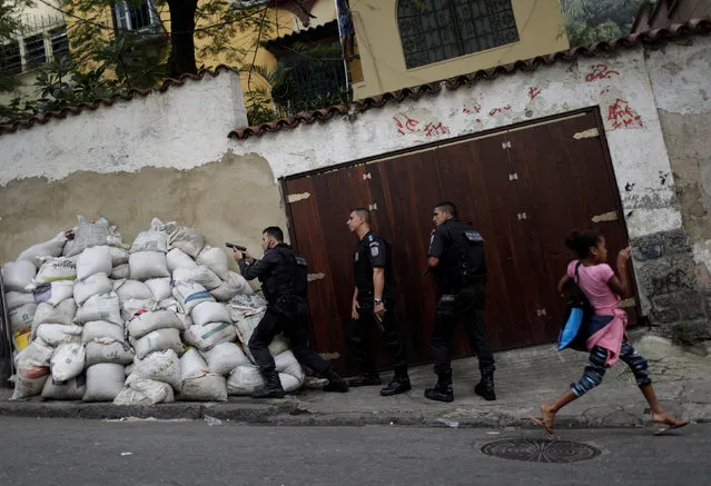 A girl reacts as police officers take up positions after a resident was shot dead during a violent clash during an operation against drug dealers in Pavao Pavaozinho slum in Rio de Janeiro, Brazil, June 28, 2017. (Photo by Ricardo Moraes/Reuters)