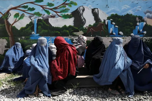 Afghan women wait to receive a food package being distributed by a Saudi Arabia humanitarian aid group at a distribution center in Kabul, Afghanistan, April 25, 2022. (Photo by Ali Khara/Reuters)