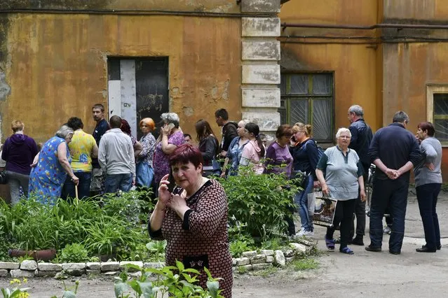 People wait to receive humanitarian aid in Kramatorsk, Ukraine, Saturday, May 28, 2022. (Photo by Andriy Andriyenko/AP Photo)