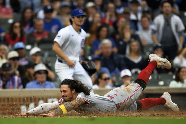Cincinnati Reds' Jonathan India slides safely into home plate on a Elly De La Cruz 2 RBI double during the tenth inning of a baseball game against the Chicago Cubs in Chicago, Sunday, September 29, 2024. (Photo by Paul Beaty/AP Photo)
