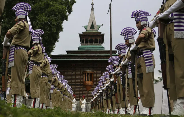 Jammu and Kashmir policemen present a guard of honor at the Martyr's graveyard in Srinagar, Indian controlled Kashmir, Thursday, July 13, 2017. July 13 is observed as Martyrs' Day in memory of the day when the region s Hindu king ordered more than 20 Kashmiri Muslims executed in a bid to put down an uprising in 1931. (Photo by Mukhtar Khan/AP Photo)