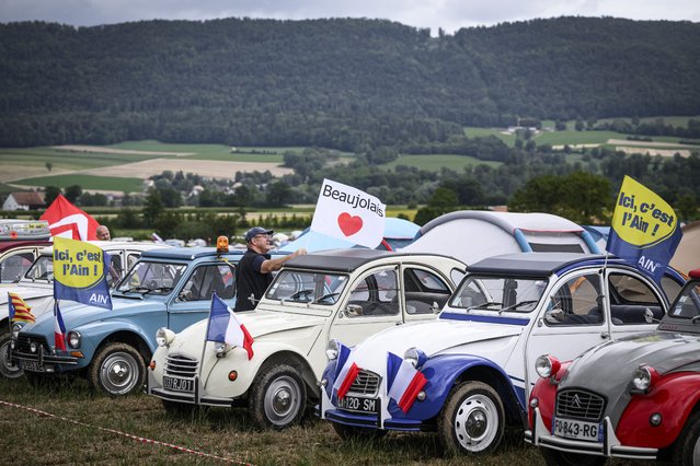 Cars are parked, lined up in a field during the 24th World meeting of Citroen 2CV friends near Delemont, northern Switzerland on July 26, 2023. Archetypal French car, the 2CV (deux chevaux), meaning “two horsepower”, and nicknamed in German “Ente” (duck) was built by carmaker Citroen with an air-cooled two-cylinder and was an economical choice for consumers. Around 5,000 Citroen 2CVs from across the globe are tootling into the Swiss countryside in a area equivalent to 75 football fields divided into a festival area and a camping ground, for a mass gathering celebrating the instantly-recognisable French classic car. (Photo by Gabriel Monnet/AFP Photo)