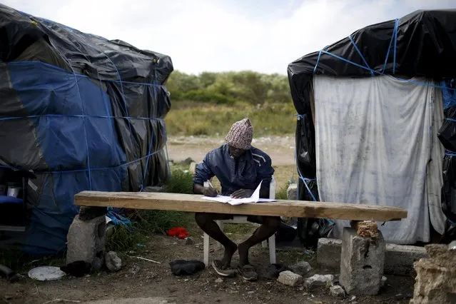 Faris, from Sudan, learns French at “The New Jungle” camp in Calais, France, August 8, 2015. For most of the 3,000 inhabitants of the “Jungle”, a shanty town on the sand dunes of France's north coast, the climax of each day is the nightly bid to sneak into the undersea tunnel they hope will lead to new life in Britain. (Photo by Juan Medina/Reuters)