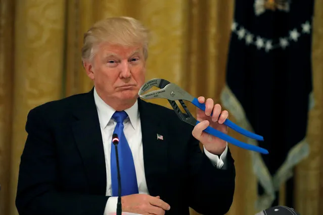 U.S. President Donald Trump holds a mechanical tool as he attends a Made in America roundtable in the East Room of the White House in Washington, U.S. July 19, 2017. (Photo by Carlos Barria/Reuters)