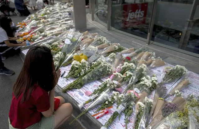 People leave flowers for the dead and injured at the scene of a deadly mass shooting outside the Terminal 21 shopping mall Monday, February 10, 2020, in Korat, Nakhon Ratchasima, Thailand. (Photo by Gemunu Amarasinghe/AP Photo)