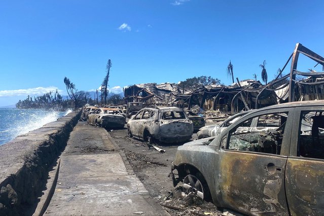 Burned cars and destroyed buildings are pictured in the aftermath of a wildfire in Lahaina, western Maui, Hawaii on August 11, 2023. A wildfire that left Lahaina in charred ruins has killed at least 55 people, authorities said on August 10, making it one of the deadliest disasters in the US state's history. Brushfires on Maui, fueled by high winds from Hurricane Dora passing to the south of Hawaii, broke out August 8 and rapidly engulfed Lahaina. (Photo by Paula Ramon/AFP Photo)