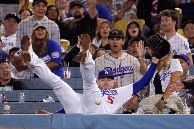 Los Angeles Dodgers second baseman Gavin Lux falls into the netting while trying to get to a foul ball hit by Chicago Cubs' Nico Hoerner during the ninth inning of a baseball game Thursday, July 7, 2022, in Los Angeles. (Photo by Mark J. Terrill/AP Photo)