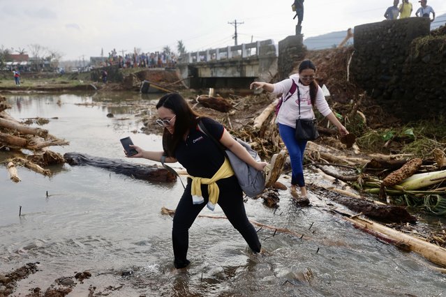 Filipino villagers cross on a river next to a damaged bridge affected by Typhoon Usagi, in the coastal municipality of Santa Ana, Cagayan province, Philippines, 15 November 2024. (Photo by Francis R. Malasig/EPA/EFE)
