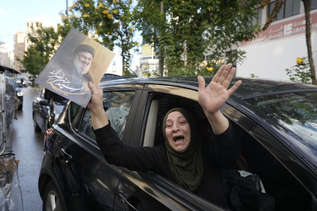 A woman carries a picture of slain Hezbollah leader Hassan Nasrallah as she returns to Dahiyeh, in Beirut, Lebanon, following a ceasefire between Israel and Hezbollah, Wednesday, November 27, 2024. (Photo by Bilal Hussein/AP Photo)