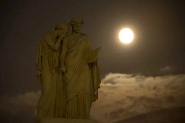 This picture provided by NASA shows a perigree full moon or supermoon is seen over the The Peace Monument on the grounds of the United States Capitol August 10, 2014, in Washington. A supermoon occurs when the moon’s orbit is closest (perigee) to Earth at the same time it is full. (Photo by Bill Ingalls/AFP Photo/NASA/HO)