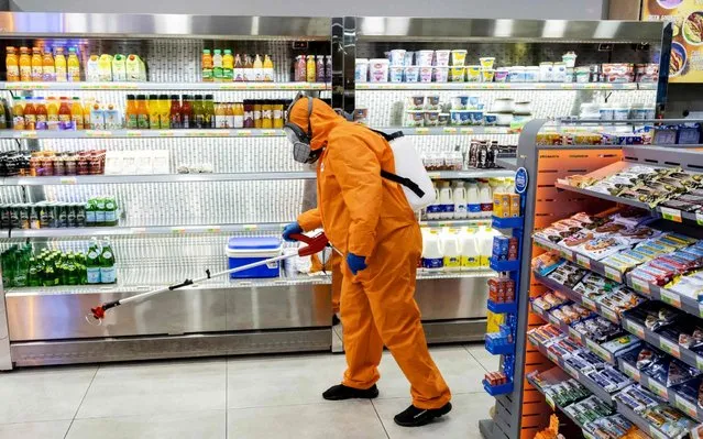 A sanitation worker sprays disinfectant inside a convenience store in the Cypriot capital Nicosia on March 20, 2020. The Republic of Cyprus has confirmed 67 Covid-19 cases and the breakaway Turkish-Cypriot north of the island another 33, making an island-wide total of 100. (Photo by Iakovos Hatzistavrou/AFP Photo)