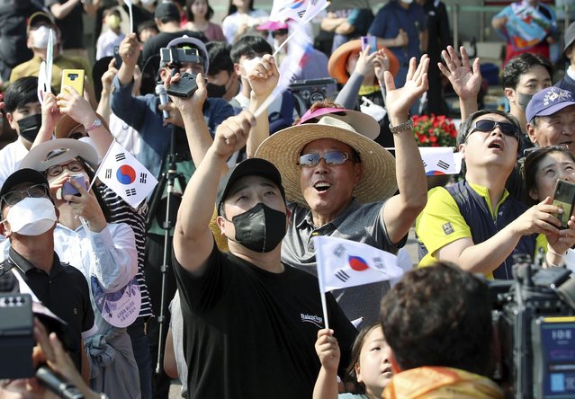 People watch the Nuri rocket, the first domestically produced space rocket, taking off from the launch pad near the Naro Space Center in Goheung, South Korea, Tuesday, June 21, 2022. South Korea launched its first domestically built space rocket on Tuesday in the country's second attempt, months after its earlier liftoff failed to place a payload into orbit. (Photo by Chun Jung-in/Yonhap via AP Photo)