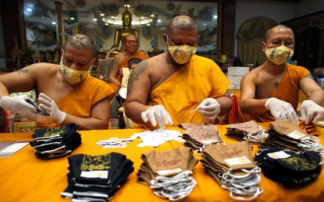 Thai Buddhist monks pack face masks inscribed with spiritual incantations at Wat Phai Lom in Nakhon Pathom province, Thailand, 29 March 2020. The face masks made by villagers are inscribed with spiritual incantations by Thai Buddhist monk Phra Kru Palad Sitthiwat, known as Luang Phi Namfon, the abbot of Wat Phai Lom, and sold by him, aimed to protect devotees from the growing fear of people in the wake of the coronavirus COVID-19 pandemic. More than 100,000 of the talisman protective masks have been sold across Thailand. Seven people have died in the country since the beginning of the coronavirus outbreak, and more than 1,300 COVID-19 infections have been reported so far. (Photo by Rungroj Yongrit/EPA/EFE)