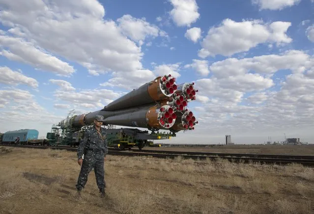 A policeman stands guard as the Soyuz TMA-18M spacecraft is transported to its launch pad at the Baikonur cosmodrome, Kazakhstan, August 31, 2015. (Photo by Shamil Zhumatov/Reuters)