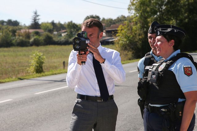 France's President Emmanuel Macron (C) uses a speed radar for cars in Villeton, southwestern France on October 2, 2023, during a visit focused on security. During a trip to the Lot-et-Garonne region, the head of state will unveil the sites for 200 new gendarmerie brigades, a 2022 campaign promise. (Photo by Bob Edme/Pool via AFP Photo)