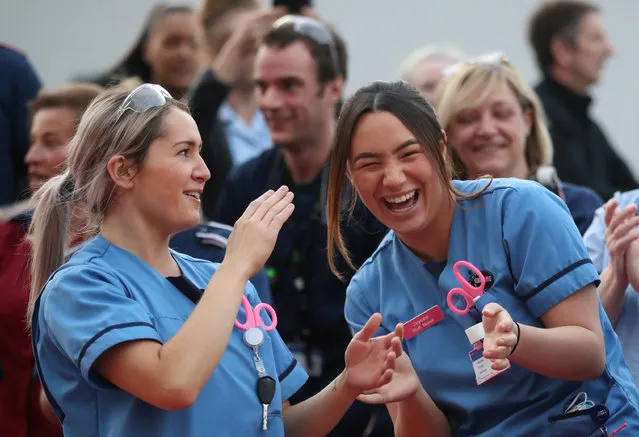 Medical staff react outside Queen Elizabeth Hospital during the Clap for our Carers campaign in support of the NHS, as the spread of the coronavirus disease (COVID-19) continues, in Birmingham, Britain, April 23, 2020. (Photo by Carl Recine/Reuters)