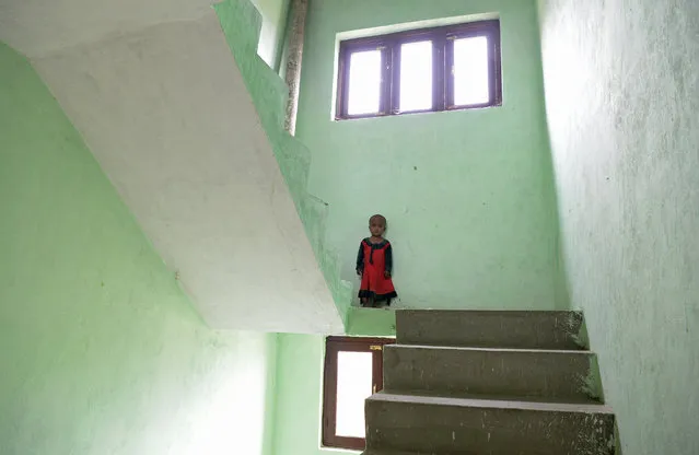 A Rohingya refugee child poses in the stairwell of a building on the outskirts of Srinagar on September 14, 2017. Eighteen families of Rohingya refugees from Myanmar have been living in Srinagar for the past six months, some of the almost 6000 Rohingya refugees who are living in 18 refugee camps in India since 2012 Rakhine state riots. After a fresh spate of violence, the number of Rohingya who have fled Myanmar for Bangladesh to escape ethnic unrest hit 389,000 and the United Nations warned of a looming “worst case scenario” with all of the Muslim minority group trying to leave. US Secretary of State Rex Tillerson on September 14,  condemned violence against Rohingya Muslims in Myanmar as “unacceptable”, as thousands of refugees continue to stream across the border into Bangladesh. (Photo by Tauseef Mustafa/AFP Photo)