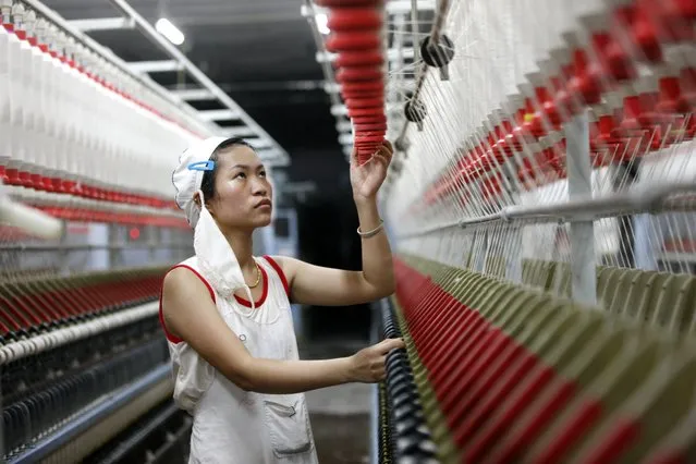 In this Friday, August 28, 2015 photo, an employee works in a textile factory in Huaibei in central China's Anhui province. Chinese manufacturing is showing signs of further weakness as two factory indexes released Tuesday, September 1, fell to multiyear lows, intensifying fears that the world's No. 2 economy is losing more momentum. (Photo by Chinatopix Via AP Photo)