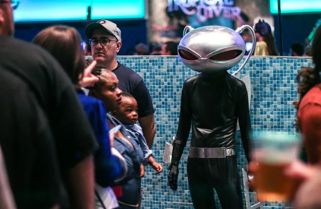 In this Saturday, September 5, 2015, photo, a man in costume looks on at fellow attendees of a private party held at the Georgia Aquarium as part of Dragon Con in Atlanta. (Photo by Ron Harris/AP Photo)