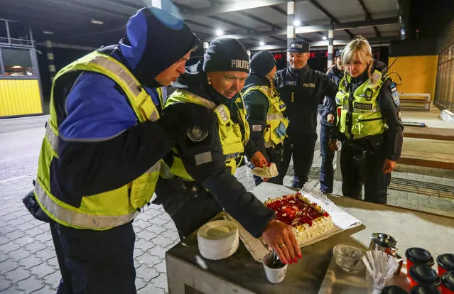 Estonian police and border guard officers pick pieces of cake at border crossing point between Estonia and Latvia, as travel restrictions for residents of Latvia, Lithuania and Estonia are lifted during the coronavirus disease (COVID-19) outbreak in Ikla, Estonia on May 15, 2020. (Photo by Ints Kalnins/Reuters)