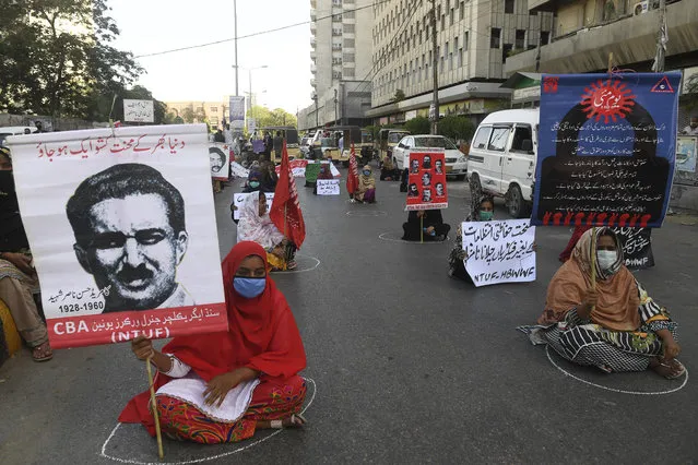 Labour union workers maintain social distancing as they carry placards during a May Day rally in Karachi on May 1, 2020. (Photo by Asif Hassan/AFP Photo)