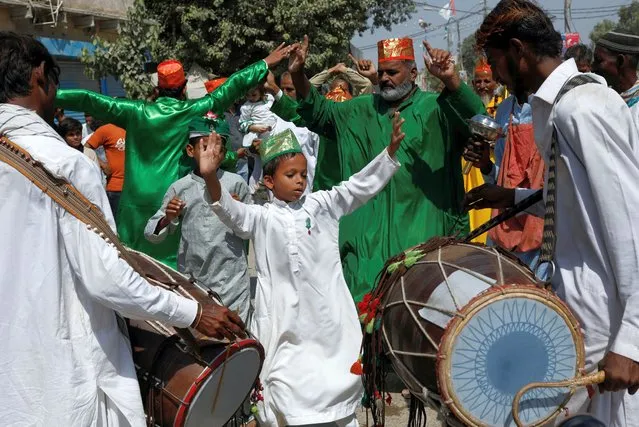 A boy performs a dance called dhamal with others during the celebrations to mark the birth anniversary of Prophet Mohammad, in Karachi, Pakistan on October 9, 2022. (Photo by Akhtar Soomro/Reuters)