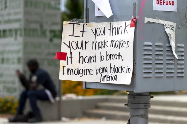 A sing posted on a street box by “Black Lives Matter” protesters, reads ”If you think your mask makes it hard to breath, Imagine being black in America”, seen at the Grand Park downtown Los Angeles, Thursday, June 18, 2020. California is now requiring people to wear masks in most indoor settings and outdoors when distancing isn't possible under a new statewide order. California Gov. Gavin Newsom previously allowed local governments to decide whether to mandate masks, and major counties like Los Angeles and San Francisco already require people to wear them inside and outside. (Photo by Damian Dovarganes/AP Photo)