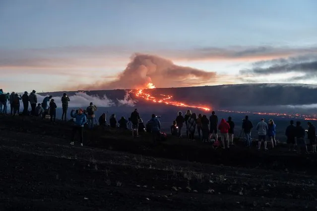 People gather to observe the eruption of the Mauna Loa Volcano in Hawaii, U.S. December 1, 2022. (Photo by Go Nakamura/Reuters)