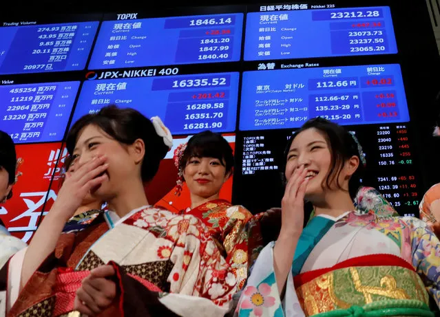 Women, dressed in ceremonial kimonos, smile in front of an electronic board displaying the Nikkei average (top in R) as they pose after the ceremony which kicks off the first day of trading in 2018 at the Tokyo Stock Exchange in Tokyo, Japan January 4, 2018. (Photo by Kim Kyung-Hoon/Reuters)