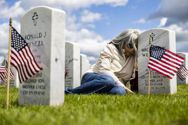 Rosie Weaver leans against the headstone of her husband, U.S. Army Spc. Michael Weaver, after a Memorial Day ceremony, Sunday, May 25, 2025, at Great Lakes National Cemetery in Holly Township, Mich. (Photo by Ayrton Breckenridge/The Flint Journal via AP Photo)