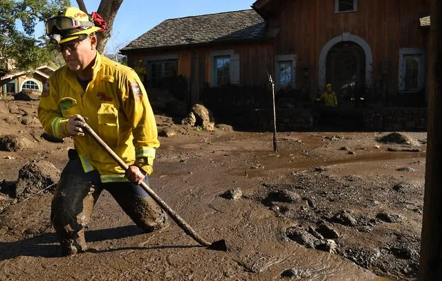 Cal Firefighter Alex Jimenez walks out after marking a spot with a stick where he found a body under the mud at a house along Glen Oaks Drive in Montecito after a major storm hit the burn area Wednesday on January 10, 2018 in Montecito, California. (Photo by Wally Skalij/Los Angeles Times via Getty Images)