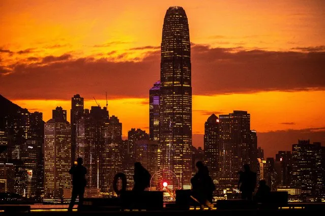 People gather at East Coast Park Precinct as city's skyline is seen during the dusk in Hong Kong on December 20, 2022. (Photo by Philip Fong/AFP Photo)