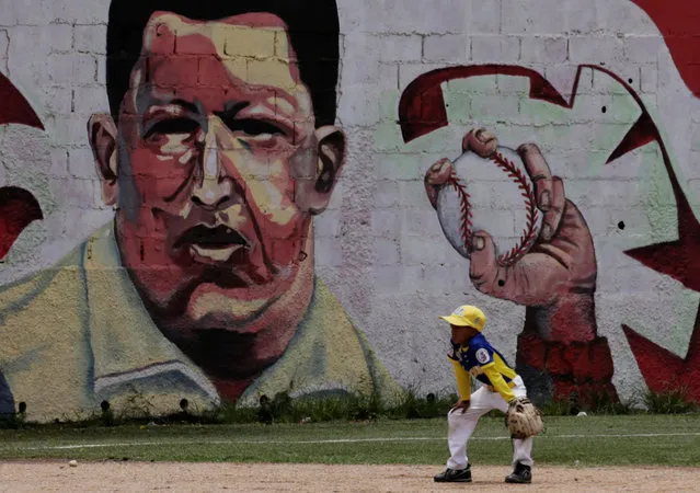 A boy plays baseball near a mural of Venezuela's late president Hugo Chavez, in Caracas, Venezuela September 8, 2016. (Photo by Henry Romero/Reuters)