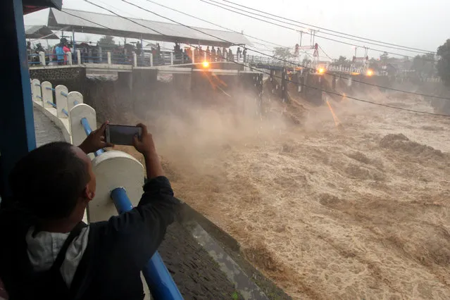 Residents watch water caused by heavy rainfall flow from the Katulampa sluice gate in Bogor City, West Java, south of Jakarta, Indonesia February 5, 2018 in this photo taken by Antara Foto. (Photo by Yulius Satria Wijaya/Reuters/Antara Foto)