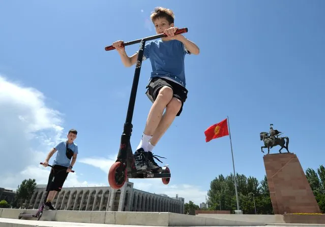 Boys ride scooters during International Children's Day  at the central Ala-Too Square in Bishkek on June 1, 2020. (Photo by Vyacheslav Oseledko/AFP Photo)